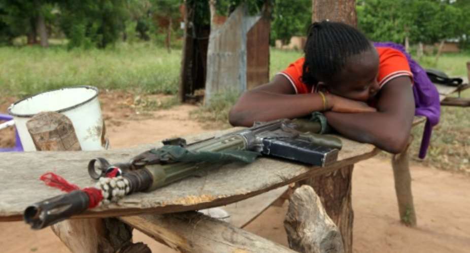 A woman lies on a riffle which she claims belong to her husband for self-defence.  By Emmanuel Arewa AFP