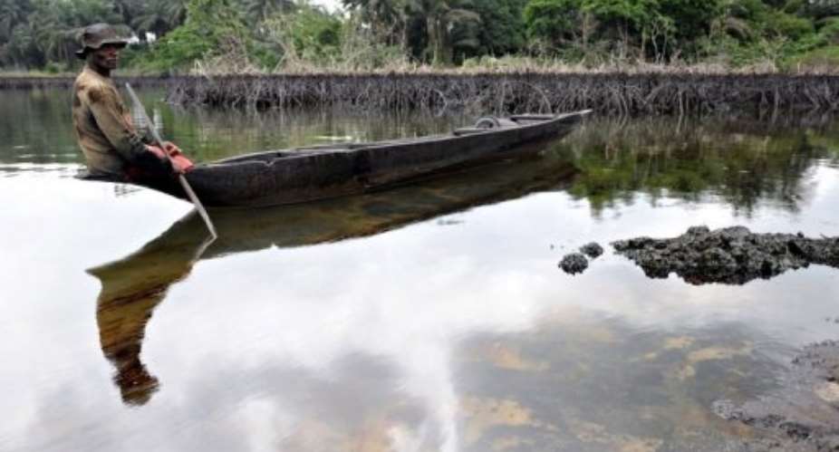 A fisherman looks at spilled crude oil floating in the waters of the Niger Delta swamps of Bodo, in 2010.  By Pius Utomi Ekpei AFPFile