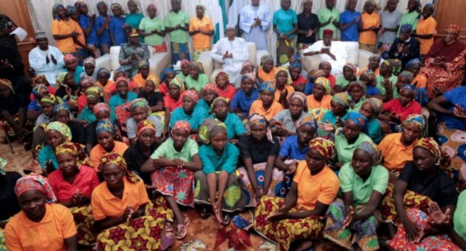 Nigeria's President Muhammadu Buhari C sitting among the 82 rescued Chibok girls during a reception ceremony at the Presidential Villa in Abuja, on May 7, 2017.  By Sunday AGHAEZE PGDBAHND Mass CommunicationAFPFile