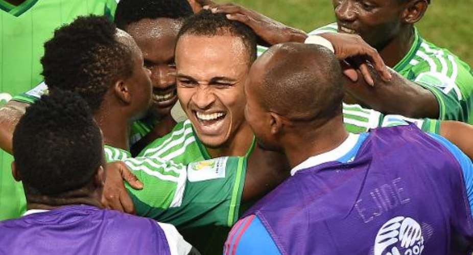 Nigeria forward Peter Odemwingie C celebrates with teammates after scoring a goal in their World Cup Group F match against Bosnia-Hercegovina at the Pantanal Arena in Cuiaba on June 21, 2014.  By Luis Acosta AFP