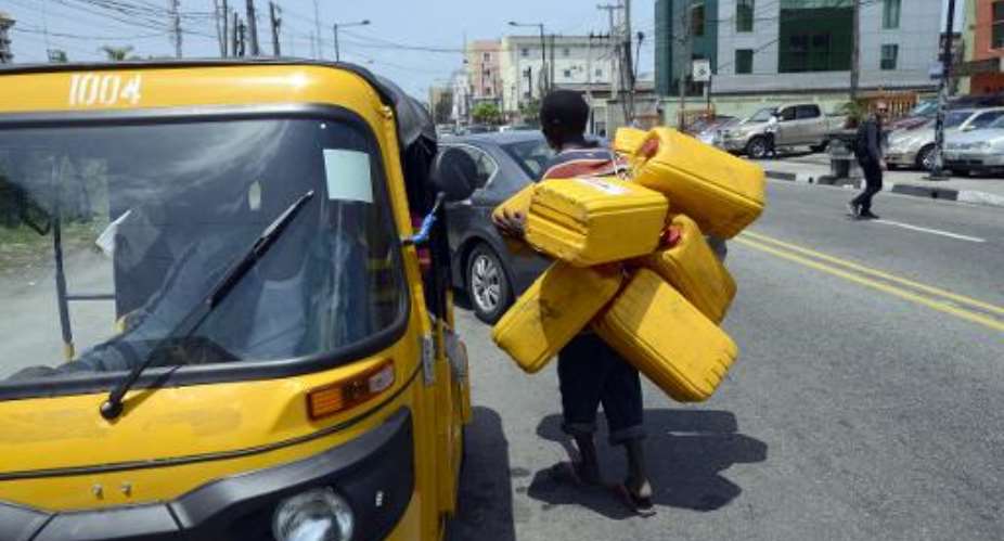 A man carries jerrycans to search for fuel in Lagos, on May 21, 2015.  By Pius Utomi Ekpei AFPFile