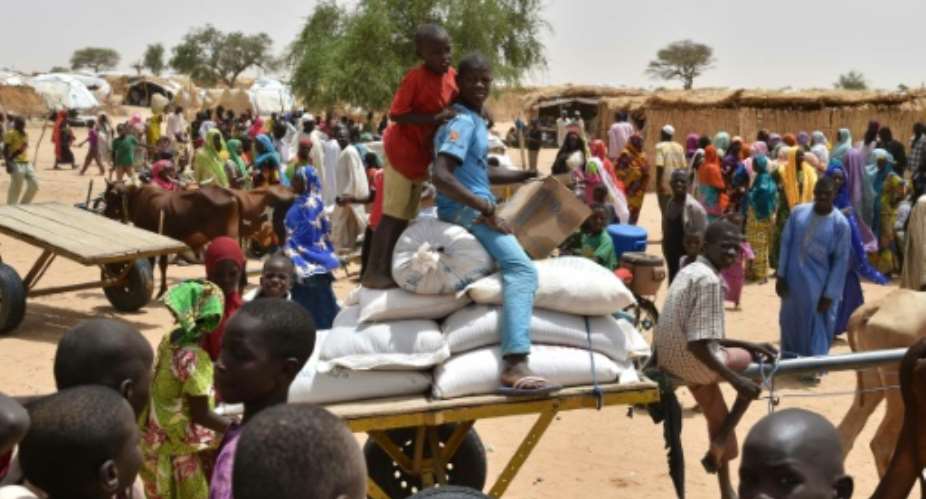 Displaced people fleeing from Boko Haram incursions into Niger wait for a food distribution at the Asanga refugee camp near Diffa on June 16, 2016 following attacks by Nigeria-based Boko Haram fighters in the region.  By Issouf Sanogo AFP