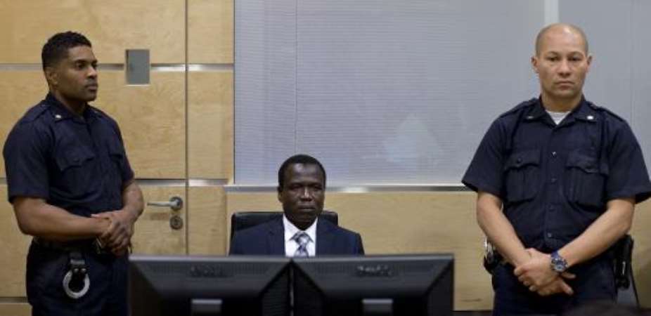 Dominic Ongwen C, a Ugandan commander in warlord Joseph Kony's feared militia takes his seat as he made his first appearance before judges at the International Criminal Court in The Hague, on January 26, 2015.  By Peter Dejong POOLAFP