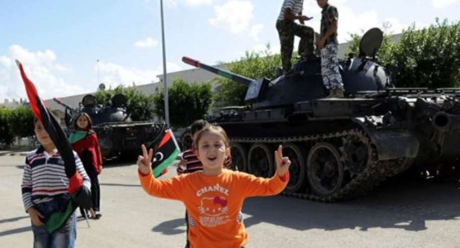 A young Libyan girl flashes the V-for-victory sign during a celebration in honour of NTC fighters on October 28.  By Philippe Desmazes (AFP/File)