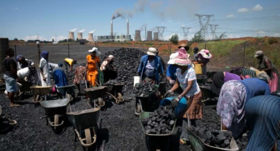 Women from Masakhane settlement fill their wheel barrows with free coal provided by the nearby mine in Emalahleni.  By Marco Longari AFPFile