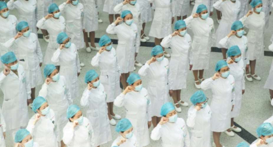 Nurses recite an oath on International Nurses Day at Tongji Hospital in Wuhan, China, where authorities have ordered the entire population be tested for the coronavirus.  By STR AFP