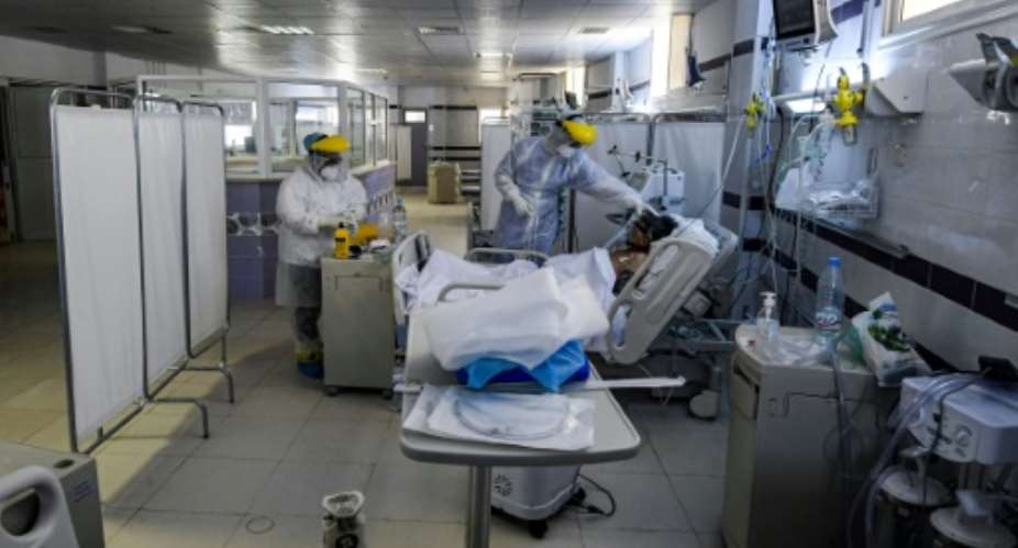 Nurses wearing personal protective equipment care for an intubated Covid-19 patient in an intensive care unit at a hospital in the town of Gabes in southwestern Tunisia.  By FETHI BELAID (AFP/File)