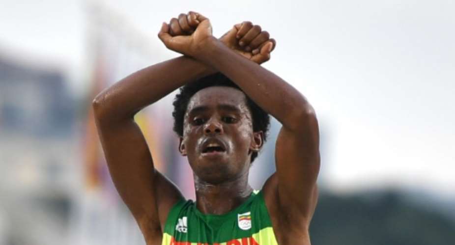 Ethiopia's Feyisa Lilesa crossed his arms above his head at the finish line of the men's marathon in Rio de Janeiro on August 21, 2016.  By Olivier Morin AFPFile