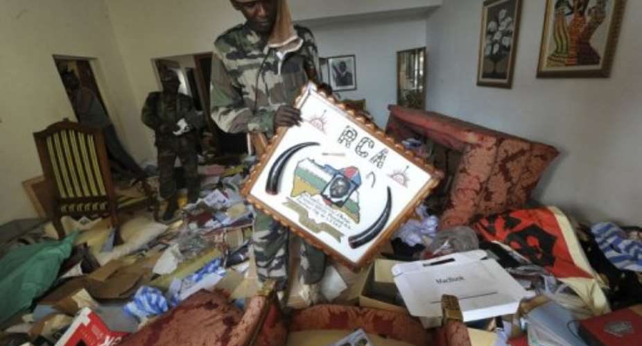 A Seleka rebel holds up a picture of former president Francois Bozize, in Bangui, on March 28, 2013.  By Sia Kambou (AFP/File)