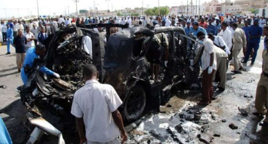 Sudanese police investigate a burnt out vehicle following a car explosion in Port Sudan.  By  (AFP)