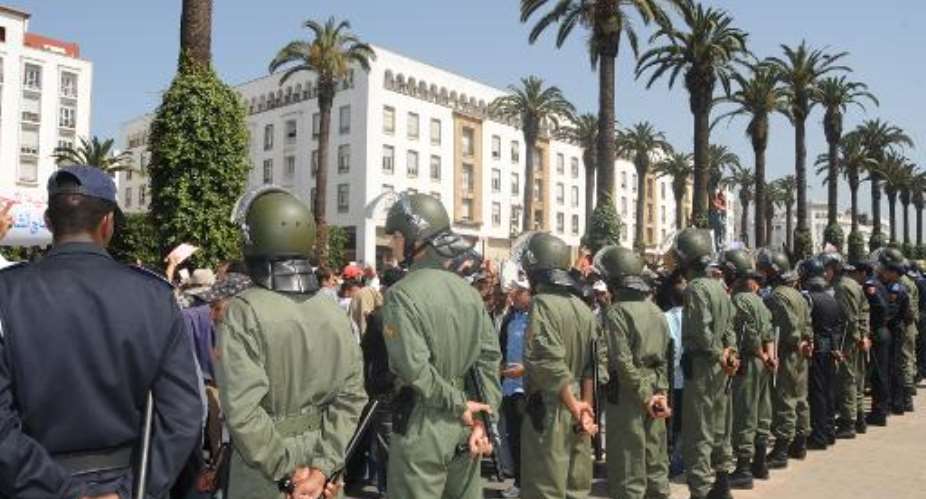 Police and soldiers stand by during a demonstration in front of parliament in Rabat on April 8, 2011.  By Abdelhak Senna AFP