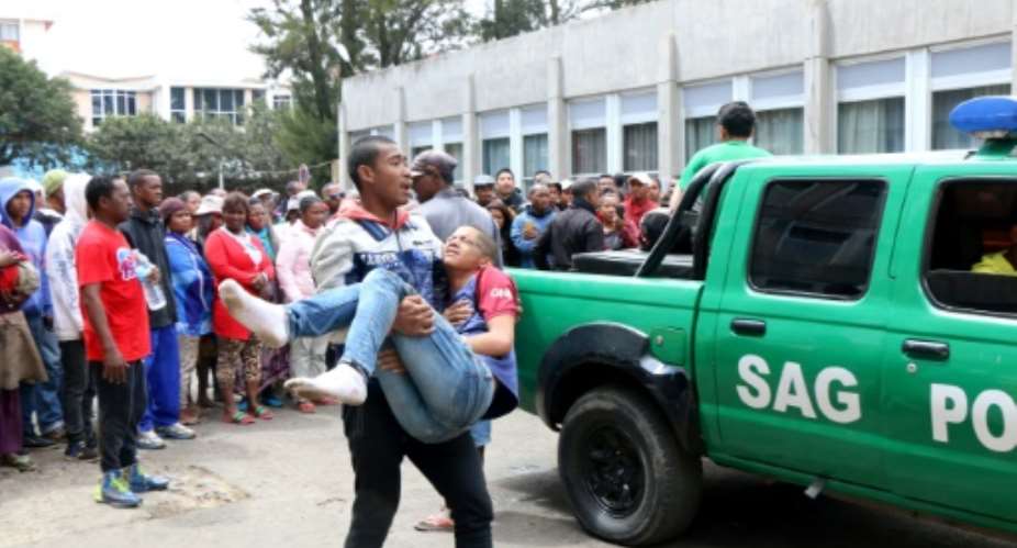 One of the nearly 40 people injured in the deadly September 9, 2018 stampede outside Madagascar's Mahamasina Stadium is carried to safety.  By Mamyrael AFPFile
