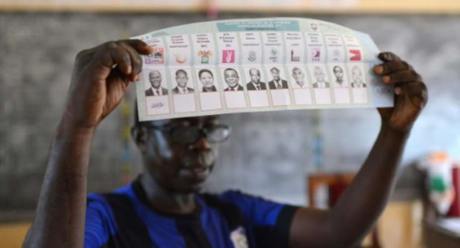 An official holds a ballot as votes are counted after polls closed in Ivory Coast's presidential election in Gagnoa on October 25, 2015.  By Issouf Sanogo AFPFile