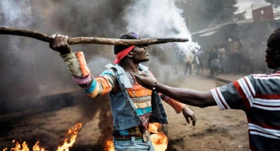Opposition supporters demonstrate at a burning barricade in Kibera slum in Nairobi on the eve of Kenya's second election in two months.  By MARCO LONGARI AFP