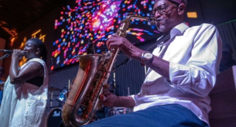 Orchestra Baobab saxophonist Thierno Koite performs alongside vocalist Korka Dieng during a concert at the Dakar nightclub Just for You in September 2026.  By SEYLLOU (AFP)