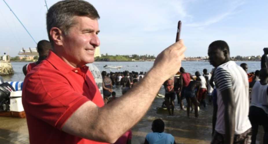US diplomat Charles Rivkin takes pictures with his smartphone on Ngor Island off the Senegalese capital Dakar, on September 12, 2015.  By Seyllou Diallo AFPFile