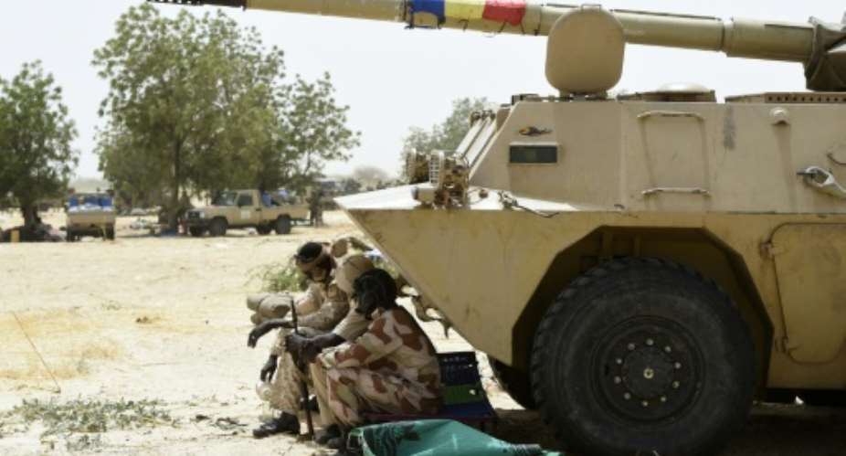 Chadian soldiers rest in the shade of their armoured vehicle near Malam Fatori in northeast Nigeria on April 3, 2015, after the town in was retaken from Boko Haram by troops from Chad and Niger.  By Philippe Desmazes AFPFile