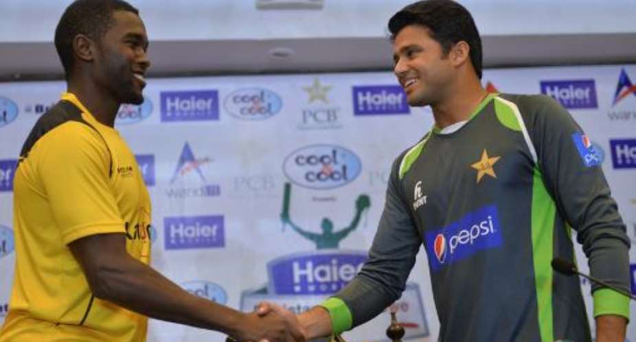 Pakistani cricket captain Azhar Ali R shakes hands with his Zimbabwe counterpart Elton Chigumbura after the unveiling of the One Day International trophy in Lahore on May 25, 2015.  By Aamir Qureshi AFP