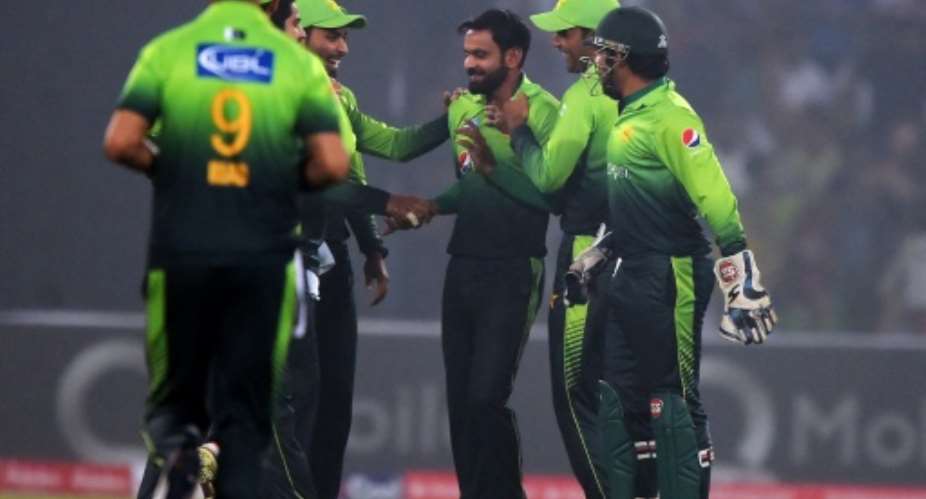 Pakistani spinner Mohammad Hafeez C celebrates with teammates after the dismissal of a Sri Lankan cricketer during a T20 match in Lahore, in October 2017.  By AAMIR QURESHI AFPFile