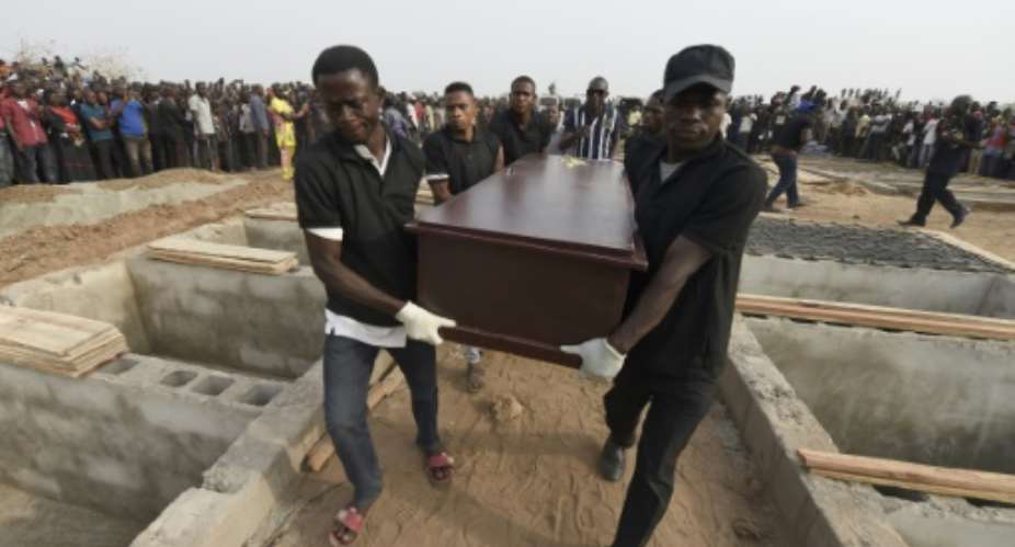 Pall bearers carry coffins during a funeral service last month for people killed during clashes between cattle herders and farmers in Nigeria's Benue state.  By PIUS UTOMI EKPEI AFP