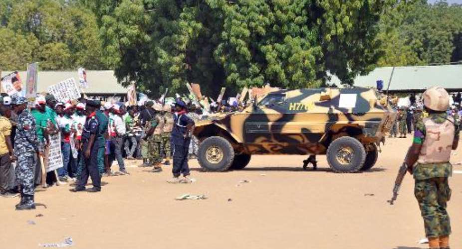 Soldiers and security block a road as they secure the venue during a rally of the ruling People's Democratic Party PDP in Maiduguri on January 24, 2015.  By Tunji Omirin AFP