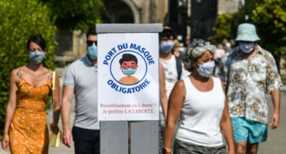 Paris has joined a growing number of French cities requiring people to wear masks in crowded outdoor areas, like the western town of Locronan where the sign instructing passersby to put on masks asks whether they prefer a lockdown or liberty.  By Fred TANNEAU AFP
