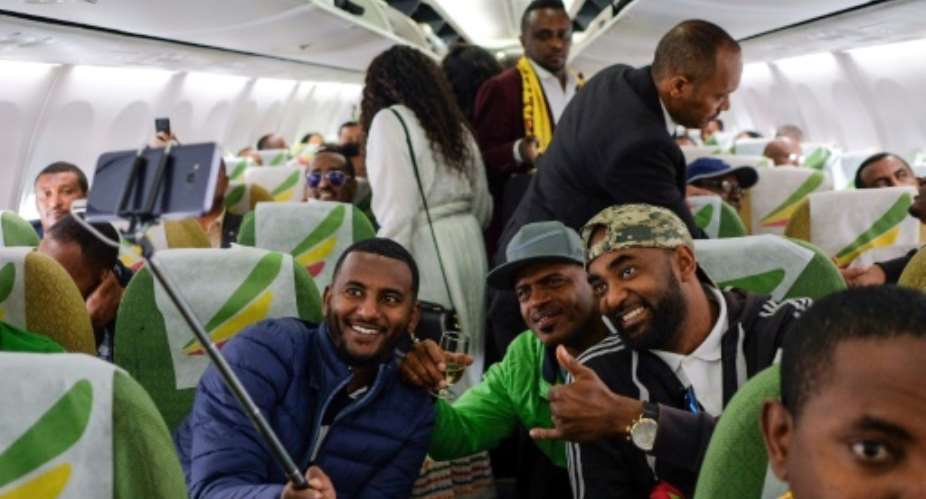 Passengers pose for a selfie aboard the Ethiopian Airlines plane -- the first flight from Addis Ababa to Eritrea in a generation.  By Maheder HAILESELASSIE TADESE AFP
