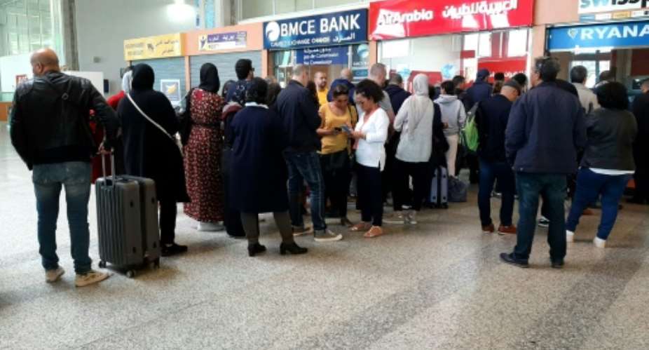 Passengers queue at the Ibn Battuta Airport in Tangiers, Morocco hoping to get a flight out of the country after it suspended links with Europe and other destinations over coronavirus fears.  By - AFP