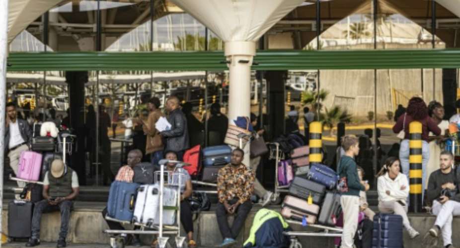 Passengers stranded at the Jomo Kenyatta International Airport.  By SIMON MAINA (AFP)