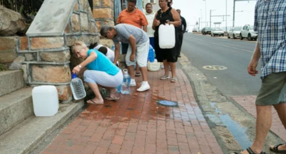 People collect drinking water from pipes fed by an underground spring.  By RODGER BOSCH AFPFile