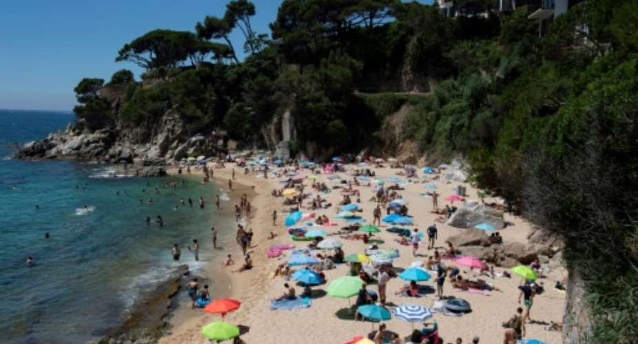 People enjoy a day out at the beach in Platja D'Aro near Girona -- Spaniards endured one of the world's toughest lockdowns for three months from March 2020.  By Josep LAGO AFP