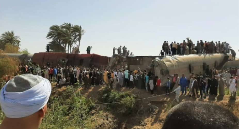 People gather on and around the wreckage of two trains that collided in the Tahta district of Sohag province, some 460 kms south of the Egyptian capital Cairo on March 26.  By - AFPFile