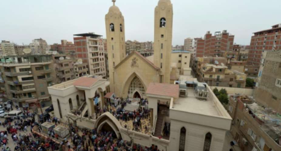 People gather outside the Mar Girgis Coptic Church in the Nile Delta City of Tanta, north of Cairo, after a bomb blast struck worshippers gathering to celebrate Palm Sunday on April 9, 2017.  By KHALED DESOUKI AFP