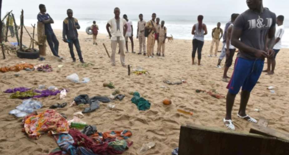 People look at clothes left on the beach following the attack.  By ISSOUF SANOGO AFP