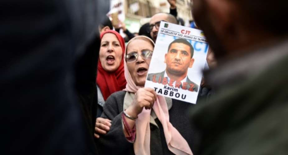 People march with signs calling for the release of detained Algerian opposition figure Karim Tabbou on January 24, 2020, during the 49th consecutive Friday demonstration against the Algerian government and the ruling class in Algiers.  By RYAD KRAMDI AFPFile
