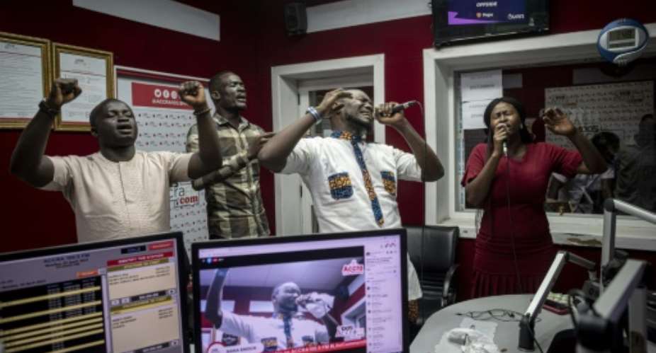 People pray and sing during a worship radio show at Accra FM station in Accra.  By CRISTINA ALDEHUELA AFPFile