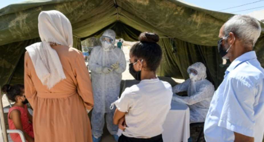 People queue to get tested for coronavirus at the field hospital in El Hamma. The town's hospital has no intensive care beds, and the army set up the field hospital in mid-August to bolster the local response and screen suspected cases.  By FETHI BELAID AFP