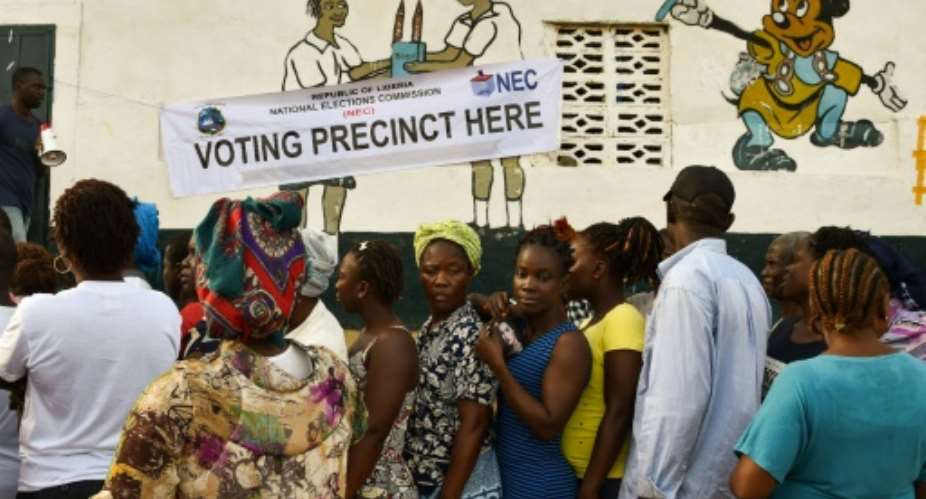 People wait in line prior to casting their vote for Liberia's presidential and legislatives elections, at a polling station in Monrovia on October 10, 2017.  By ISSOUF SANOGO AFPFile