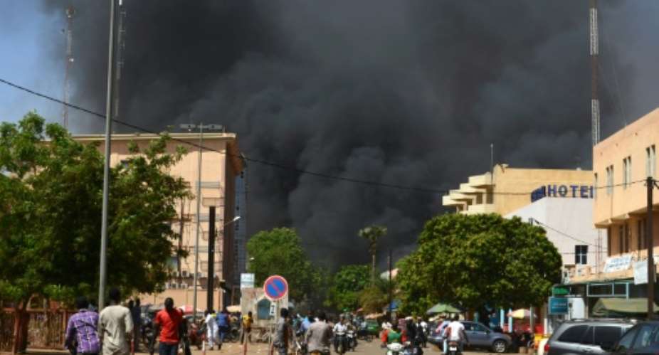 People watch as black smoke rises during twin jihadist attacks targeting the French embassy and Burkina Faso's military headquarters.  By Ahmed OUOBA AFPFile