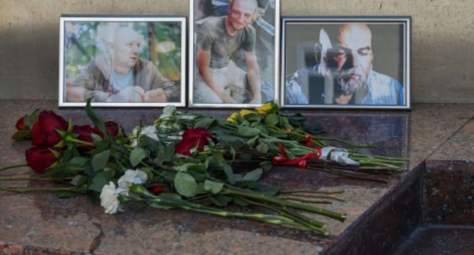 Photographs of Russian journalists L-R Alexander Rastorguyev, Kirill Radchenko and Orkhan Dzhemal, who were killed in Central African Republic, were left outside the Central House of Journalists in Moscow.  By Vasily MAXIMOV AFP