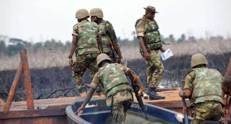 The Joint Take Force inspects a barge seized from oil thieves at Bodo waterways, Ogoniland in Rivers State on April 12, 2011.  By Pius Utomi Ekpei (AFP/File)