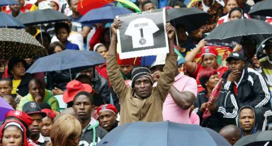 A fan gestures as thousands of South Africans brave the rain and cold weather to gather at the Moses Mabhida stadium to pay their final respects to the late Senzo Meyiwa, during his funeral in Durban on November 1, 2014.  By Rajesh Jantilal AFPFile
