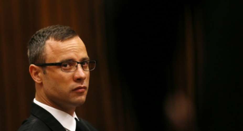 Paralympic track star Oscar Pistorius sits in the dock ahead of his trial for the murder of his girlfriend Reeva Steenkamp, in Pretoria, on March 25, 2014.  By Siphiwe Sibeko POOLAFPFile