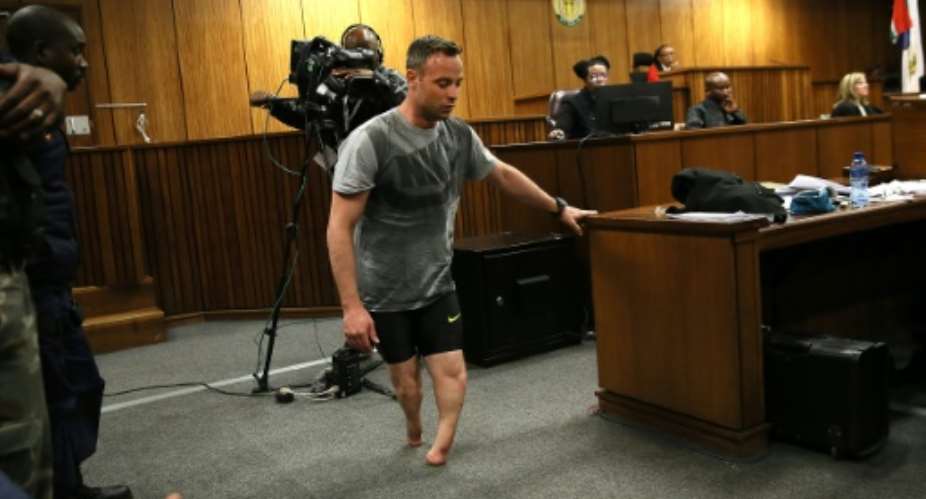 Oscar Pistorius walks without his prosthetic legs during his resentencing hearing for the 2013 murder of his girlfriend Reeva Steenkamp at the Pretoria High Court on June 15, 2016.  By Alon Skuy PoolAFP