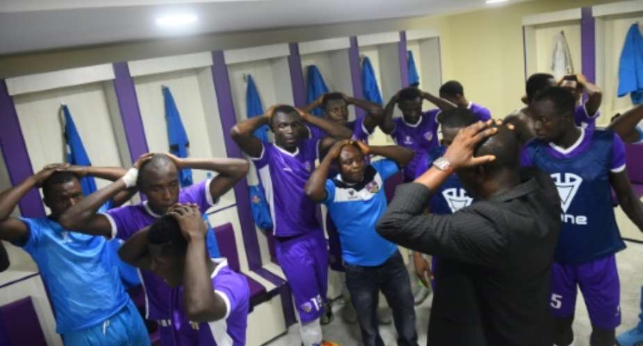 Players and officials of Mountain of Fire and Miracles Ministries football club pray in the changing room before a game at Agege Stadium.  By PIUS UTOMI EKPEI AFP