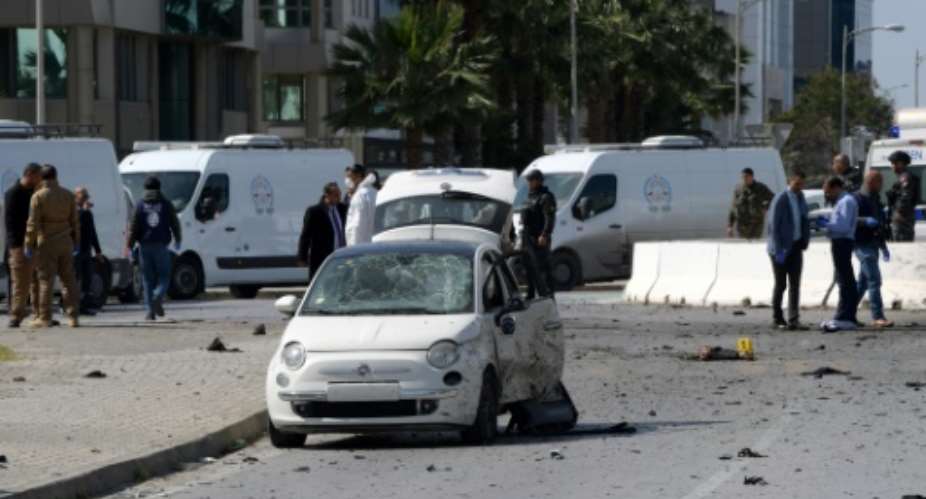 Police and forensic experts gather at the scene of an explosion near the US embassy in Tunis.  By Fethi Belaid AFP