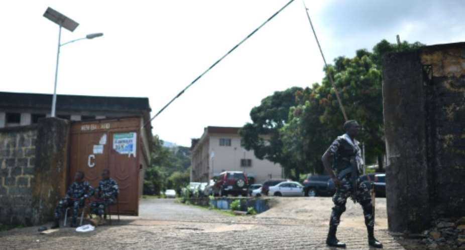 Police guard the entrance to the Sierra Leone Broadcasting Corporation in Freetown following the clashes in which 13 soldiers were killed amid a report of two civilian fatalities.  By Saidu BAH AFP