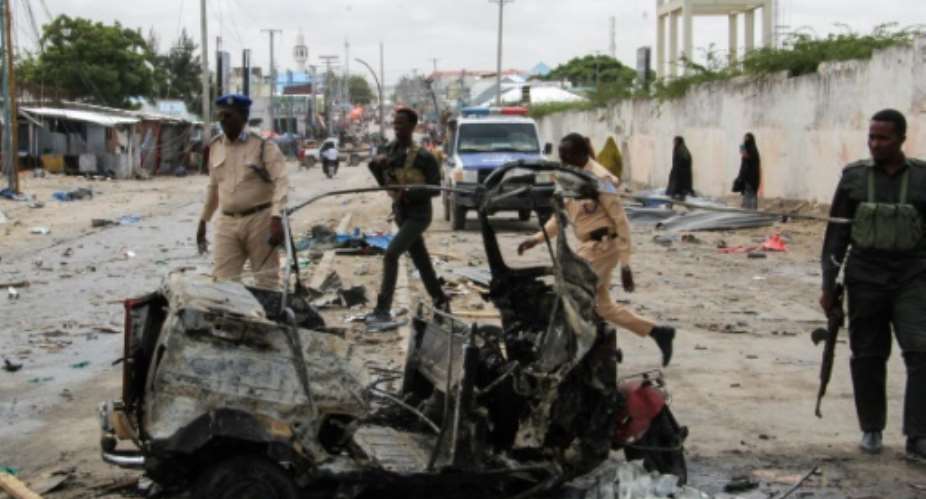 Police officers at the scene of a suicide car bomb attack on July 10 that targeted Mogadishu's police commissioner.  By - AFP
