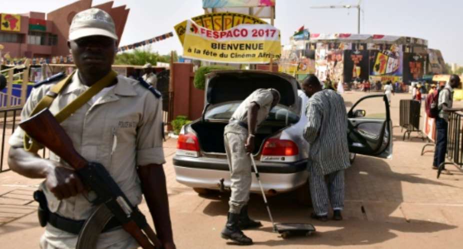 Police officers check cars at the entrance to the Pan-African Film and Television Festival FESPACO in Ouagadougou on February 27, 2017.  By ISSOUF SANOGO AFP