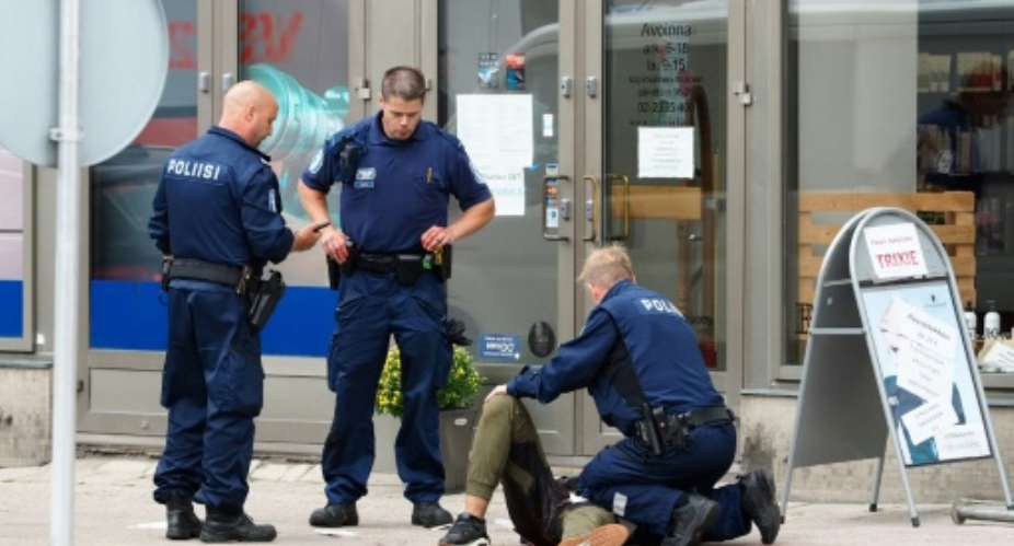 Police officers detain the Moroccan suspect who was shot in the leg, in the Finnish city of Turku after a stabbing spree that left two people dead..  By Kirsi Kanerva AFP